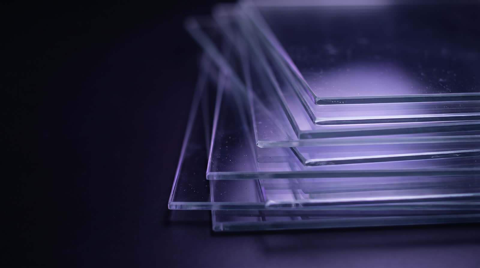 Láminas de vidrio apiladas como páginas con luz violeta