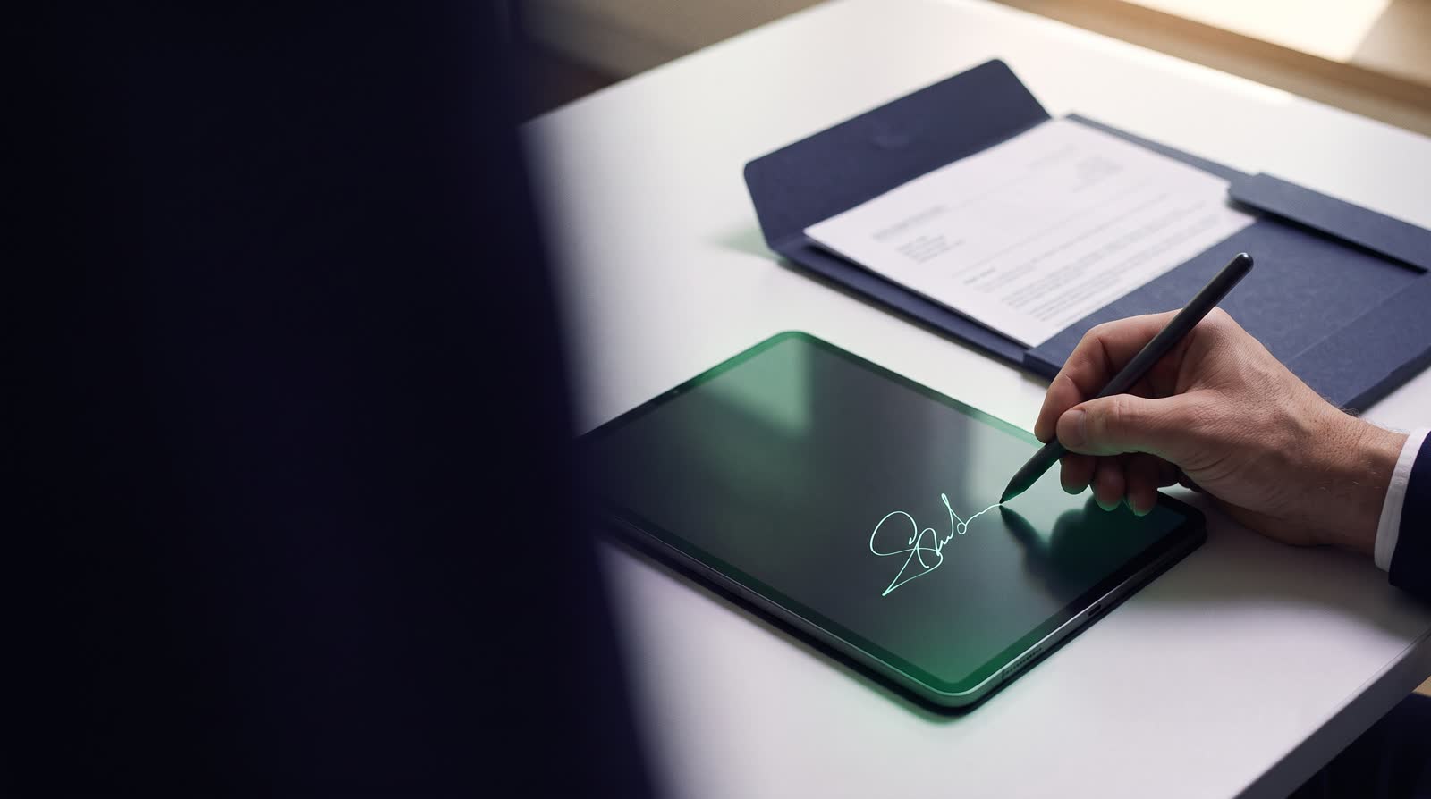 Una persona firma un documento en una tableta